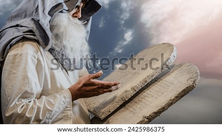 The Old Testament prophet Moses holds tablets with ten  commandments on a white background