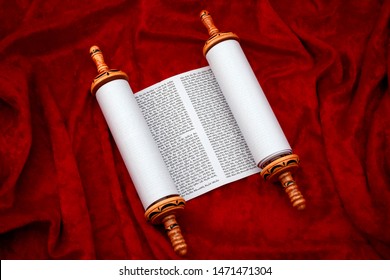 The Old Testament Text, Jewish Temple Or Synagogue, Religious Parchment Scroll And The Judaic Religion Concept Theme With The Holy Torah Open On Red Velvet Background