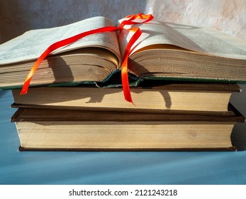 Alte dicke Bücher liegen in einem Stapel auf dem Tisch. Das Top-Buch ist offen. Lesezeichen oben auf den geöffneten Seiten. Das Konzept der wissenschaftlichen Arbeit, das Lesen der Bibel, Monographien, gewinnen Wissen.