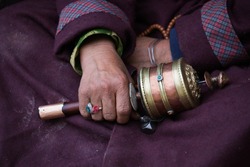 Old Tibetan Woman Holding Buddhist Prayer Wheel In Lamayuru Gompa, , Ladakh, India. Hand And Prayer Wheel, Close Up
