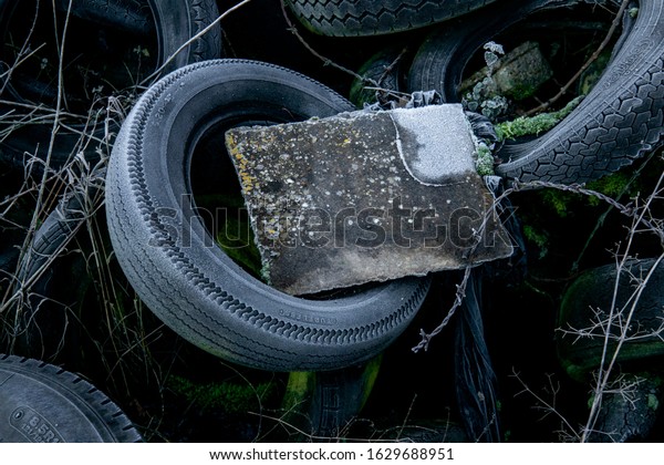 Old tires dumped in a field. Industrial
waste / rubbish background. UK rural
crime.
