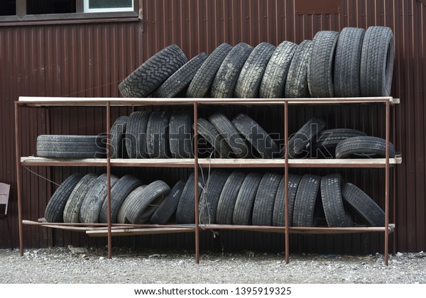 Old tires stacked on the rack in the repair shop.\
Old tires on the shelf