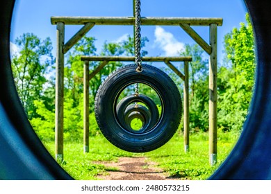 old tires as swing at a playground - photo - Powered by Shutterstock