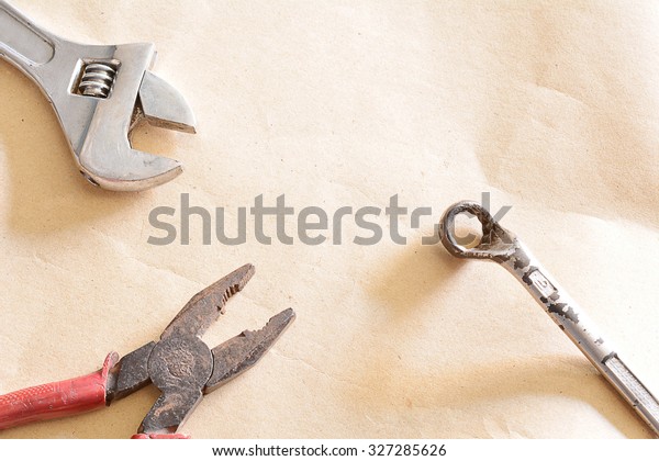 Old Tools for Auto Repair on Simple Brown\
Paper Background