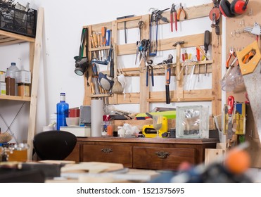 Old Tools Hanging On Wall In Workshop, Tool Shelf Against A Wall In Family Garage