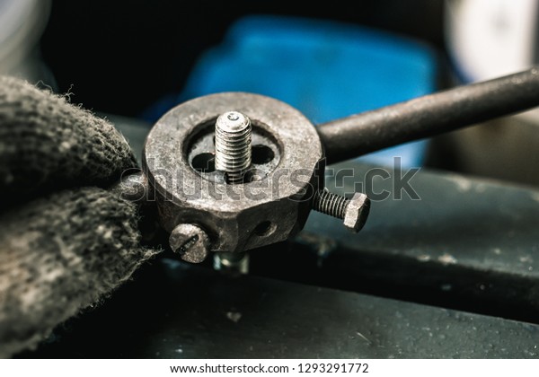 Old tools ,Mechanic using Taps and Dies tool Making\
Internal and External Threads nut at motorcycle garage .selective\
focus