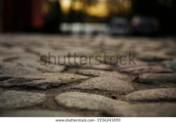Old town in Europe\
at sunset with retro vintage cobble stone. cobble paving Stones\
background for walking. 