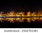 The Old Town of Gdansk at night, with its reflection in the calm waters of the Motlawa River. Picturesque image of Gdansk