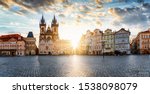 The old town square of Prague, Czech Republic, during sunrise without people surounded by the historical, gothic style buildings and the famous Tyn Church