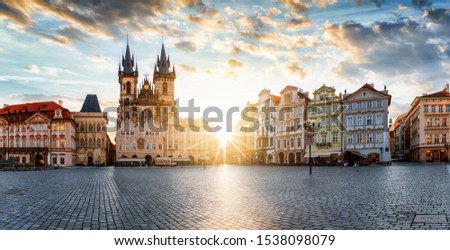 The old town square of Prague, Czech Republic, during sunrise without people surounded by the historical, gothic style buildings and the famous Tyn Church