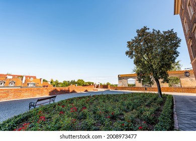 Old Town Warsaw Warszawa, Poland With People Near Barbican Fortification Fort With Brick Red Wall In Summer And Rose Garden