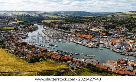 Old town Whitby from the sky, boats on the river, sunny cloudy day, old buidings, seaside town, North Yorkshire,  England, River Esk, Captain Cook