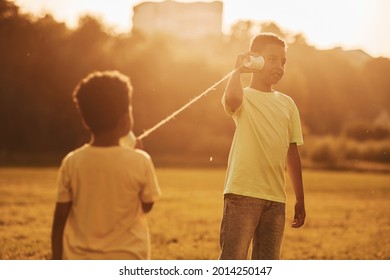 Old Toy Phone. Two African American Kids Have Fun In The Field At Summer Daytime Together.