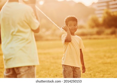 Old Toy Phone. Two African American Kids Have Fun In The Field At Summer Daytime Together.