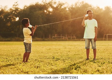 Old Toy Phone. Two African American Kids Have Fun In The Field At Summer Daytime Together.