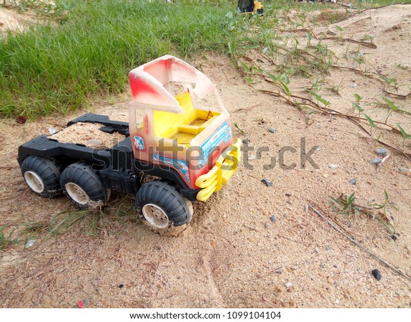 Old toy truck on the pile\
of sand