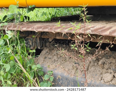 The old track of an excavator, rusty and covered in wild plants