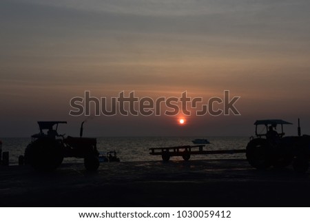 Old tractor is loading a tourist boat at sunset.Pattaya, Thailand