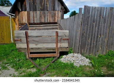 An Old Tractor Trailer Is Parked Near A Rural House On A Summer Day