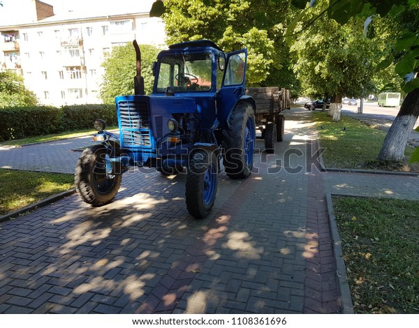 old tractor\
with old wooden trailer in the\
city