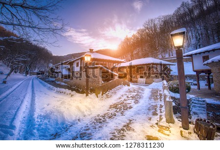Old traditional Bulgarian house in Architectural Ethnographic Complex Etar (Etara) near town of Gabrovo , Bulgaria. Open Air Museum at winter time with a snow at sunset. History tourism