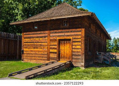 An old traditional rustic wooden house log cabin with a small windows. Wooden mountain house built from wood logs in a rural area. Brown wooden village house built with oak trees. Old timber cottage