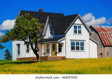 Old traditional style farmhouse with a nearby barn.