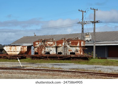 Old train cargo wagons rusting in an industrial yard