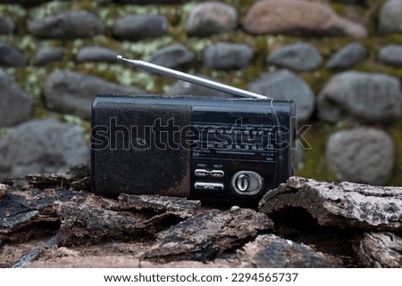 Old transistor radio on outdoor nature background.