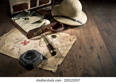 Old treasure map with colonial style pith hat, bras telescope and compass.