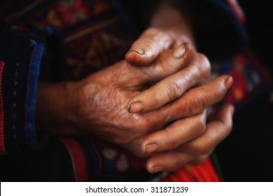 Old tribal woman with wrinkle hands clasped.