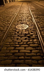 Old Trolley Tracks And Cobblestones Survive Under The Flaking Asphalt Pavement Of This Brooklyn Heights Street, Brooklyn, New York. A Night Time Exposure.