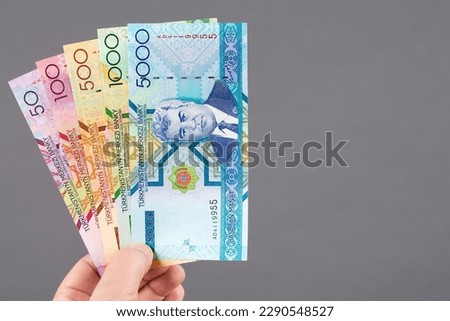 Old Turkmen money - manat in the hand on a gray background