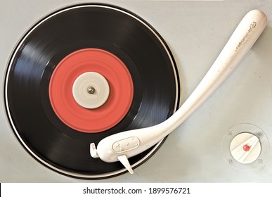 An old turntable on which an old vinyl is spinning
