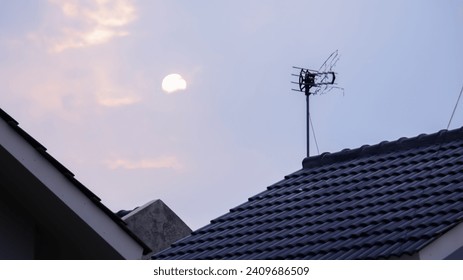 Old TV Antenna Installed on house Rooftop in evening sky background. - Powered by Shutterstock