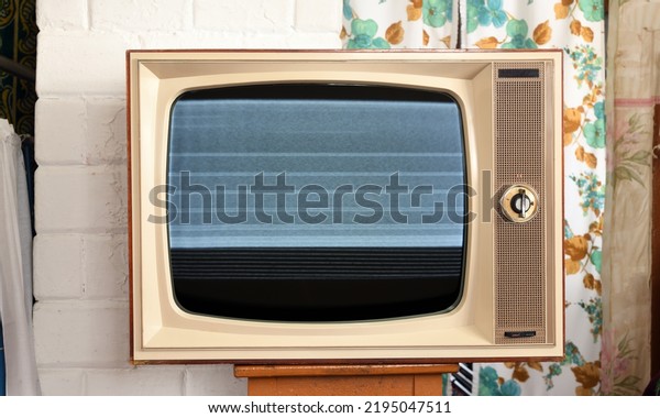 Old TV with interference and noise on the\
screen in a rustic\
interior.