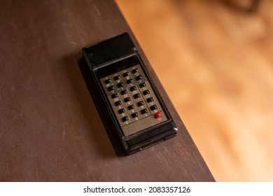 Old TV Remote At The Edge Of A Wooden Table, Detail