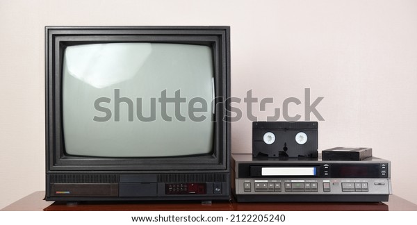 Old TV with\
VCR on the background of\
wallpaper.