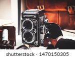 Old twin lens reflex camera and leather equipment in front of the brown leather handbag. Gentleman style photography.
Analog photography machine.

