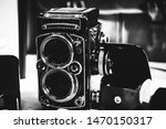 Old twin lens reflex camera and leather equipment in front of the brown leather handbag. Gentleman style photography.
Analog photography machine.

