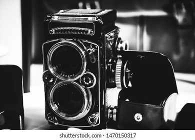 Old twin lens reflex camera and leather equipment in front of the brown leather handbag. Gentleman style photography.
				Analog photography machine.
				
				