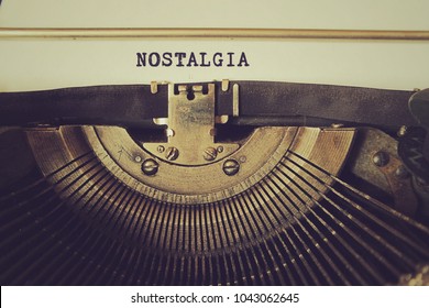 Old typewriter writes word "nostalgia" on a piece of paper. Vintage toned photo. - Shutterstock ID 1043062645
