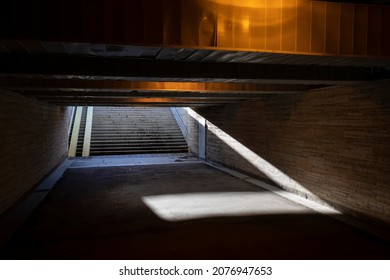 Old underground pedestrian tunnel, crossing the city street highway. Dim tunnel poorly lit by a lamp. - Powered by Shutterstock