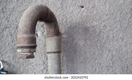 old unused pipe with a padlock hanging on the wall - Shutterstock ID 2022410792