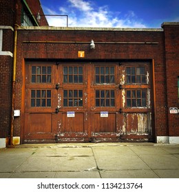 Old Urban Industrial Neighborhood Garage With A Red Brick Building Facade. Quality Background Or Wallpaper For A Variety Of Themes Including: Vintage, Rustic, Industrial, Urban, And Grunge. 