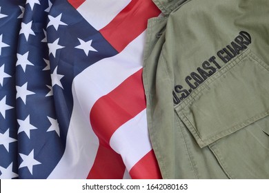 Old US Coast Guard uniform lies on folded United States Flag