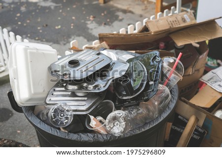 Old used Automatic Transmission Filter ,foam food box ,plastic water bottle and plastic cup in garbage bin.