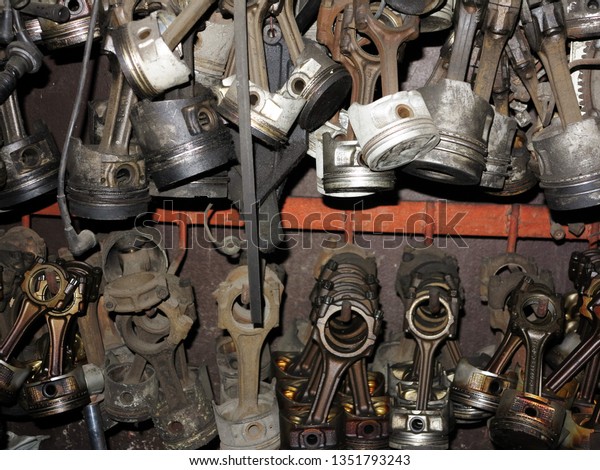 The old or used automobile pistons with rods\
were hung on the wall in the\
garage.