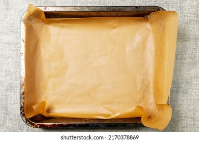 Old Used Baking Tray With Brown Paper. Cooking Food In The Oven. Preparation For Baking Meat, Fish And Bakery Products. Simple Table Cloth Background. Top Down View