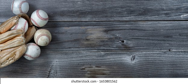 Old Used Baseballs And Weathered Glove On Vintage Wooden Background. Baseball Sports Concept With Copy Space